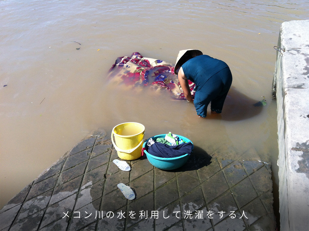 メコン川の水を利用して洗濯をする人