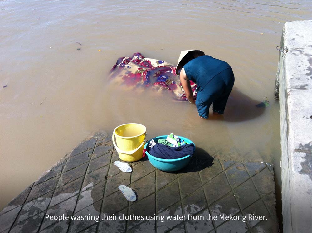 People washing their clothes using water from the Mekong River. 